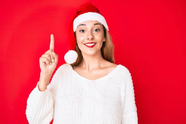 Молодая Брюнетка Рождественской Шляпе Указывающая Пальцем Успешную Идею Взволнован Счастлив — стоковое фото