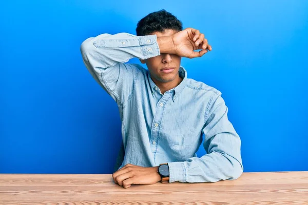 Молодий Афроамериканець Одягнений Повсякденний Одяг Сидить Столі Закриваючи Очі Руками — стокове фото