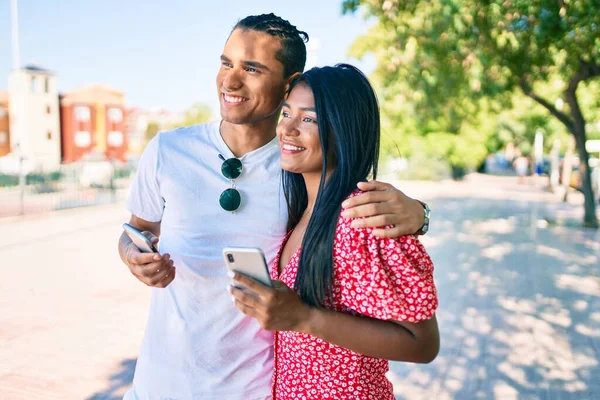 Молода Латинська Пара Посміхається Щасливий Використовуючи Смартфон Вулиці Міста — стокове фото