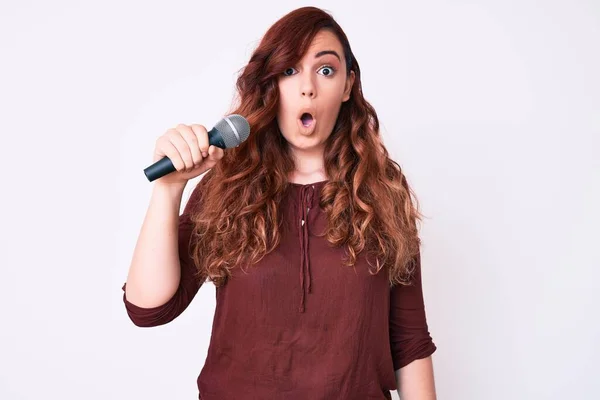 Young Beautiful Woman Singing Song Using Microphone Scared Amazed Open — Stock Photo, Image