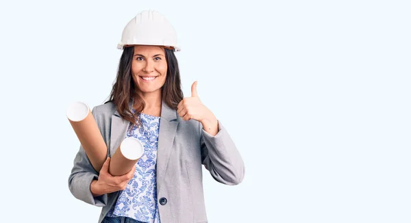 Junge Schöne Brünette Frau Trägt Architekt Hardhat Hält Blaupause Lächelnd — Stockfoto