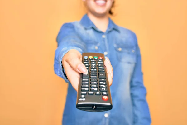 Mulher Mudando Canal Televisão Segurando Controle Remoto Sobre Fundo Amarelo — Fotografia de Stock