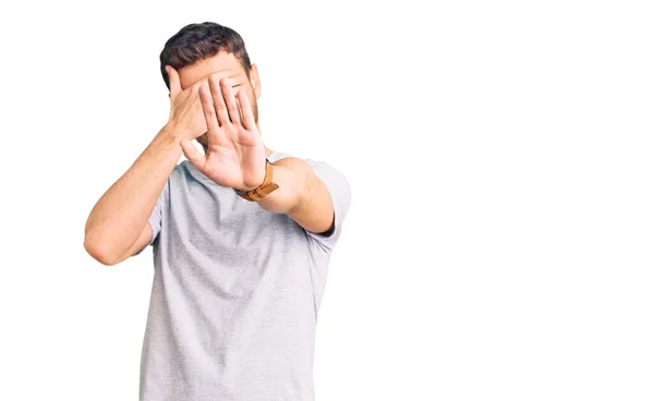 Handsome Young Man Bear Wearing Casual Tshirt Covering Eyes Hands — Stock Photo, Image