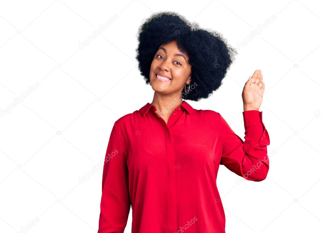 Young african american girl wearing casual clothes waiving saying hello happy and smiling, friendly welcome gesture 