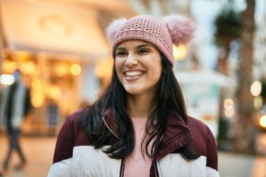 Genç İspanyol kız gülümseyerek şehirde mutlu mesut dikiliyor..