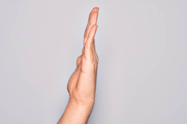 Beyaz arka planda parmaklarını gösteren beyaz tenli bir gencin eli uzatılmış el hareketlerini gösteriyor.