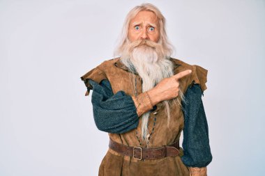 Gri saçlı, uzun sakallı, Viking kostümü giyen yaşlı bir adam endişeli, endişeli ve şaşırmış bir ifade takınıyor. 