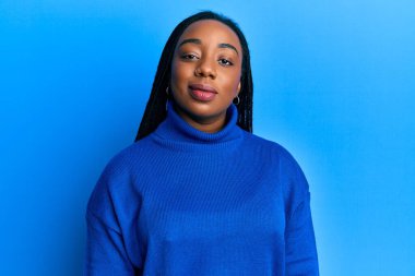 Sıradan bir kazak giyen genç Afrikalı Amerikalı kadın yüzünde ciddi bir ifadeyle rahatladı. Basit ve doğal bir şekilde kameraya bakıyorsun.. 