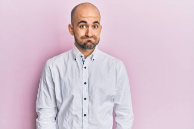 Günlük kıyafetler giyen genç İspanyol adam komik yüzlü yanakları şişiriyor. Havayla şişmiş ağız, çılgın bir ifade.. 