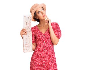 Yazlık şapka takan genç ve güzel bir kadın elinde ciddi bir yüzle eli çenesinde soru soran kafa karıştırıcı bir fikir hakkında düşünceli. 