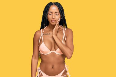 Güzel İspanyol kadın diş ağrısı ya da diş hastalığından dolayı bikini giyip ağızlarına acı dolu bir ifadeyle dokunuyor. dişçi 