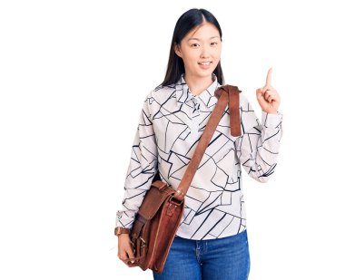 Elinde evrak çantası olan genç ve güzel bir Çinli kadın bir fikre ya da soru işaretine şaşırdı ve mutlu bir yüzle işaret etti. 