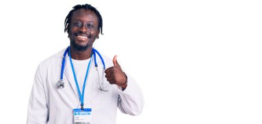 Doktor steteskopu ve kimlik kartı takan, gülümseyen, mutlu ve pozitif gülümseyen, mükemmel ve onay işareti olan Afro-Amerikan genç adam. 