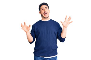 Gündelik kıyafetler giyen genç İspanyol adam deli gibi bağırıyor ve agresif bir ifade ve kollarla bağırıyor. hüsran kavramı. 