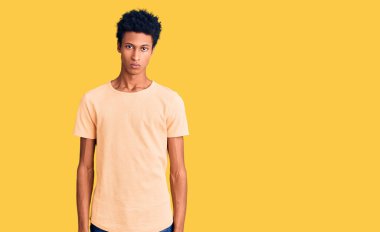 Gündelik kıyafetler giyen, kuşkucu ve gergin, sorun yüzünden surat asan genç Afro-Amerikan. negatif kişi. 