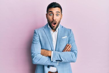 Kollarını kavuşturmuş genç İspanyol iş adamı şaşırmış ve şaşırmış bir ifade, korku ve heyecanlı bir yüz ifadesiyle korkmuş ve şok olmuştu.. 