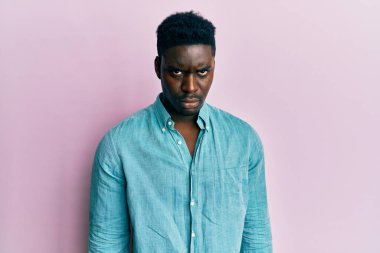 Yakışıklı, sıradan giyinen, kuşkucu ve gergin, sorun yüzünden surat asan siyahi bir adam. negatif kişi. 