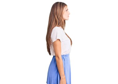 Yaz stili giyinmiş genç, sarışın bir kadın. Taraf arıyor, rahat bir poz veriyor. Kendine güvenen bir gülümsemesi var.. 