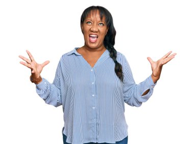 İspanyol orta yaşlı kadın gündelik kıyafetler giyip deli gibi bağırıyor, agresif bir ifadeyle bağırıyor ve kollarını kaldırıyor. hüsran kavramı. 