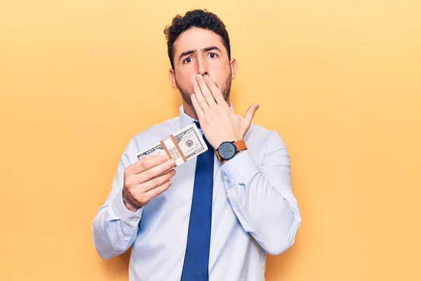 Young Hispanic Man Wearing Business Clothes Holding Dollars Covering Mouth — 图库照片