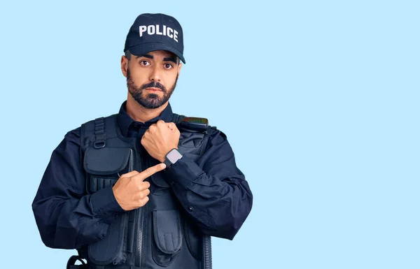 Jovem Hispânico Vestindo Uniforme Policial Com Pressa Apontando Para Assistir — Fotografia de Stock