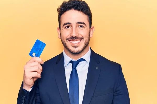 Joven Hombre Hispano Usando Traje Con Tarjeta Crédito Mirando Positiva —  Fotos de Stock