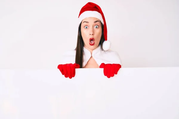 Young Woman Wearing Santa Claus Costume Holding Blank Empty Banner — Stock Photo, Image