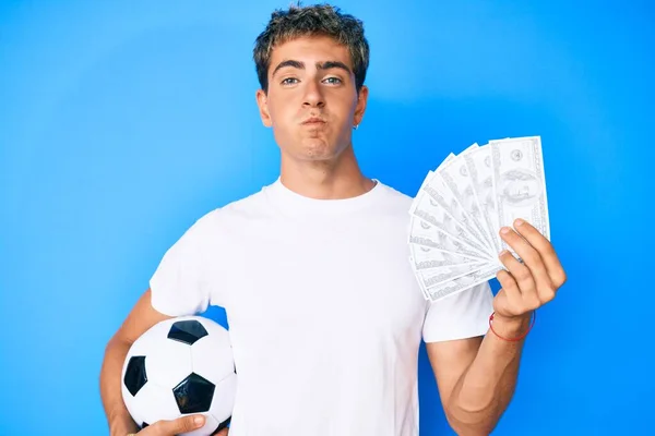 Ung Stilig Man Håller Fotboll Och Dollar Sedlar Puffande Kinder — Stockfoto