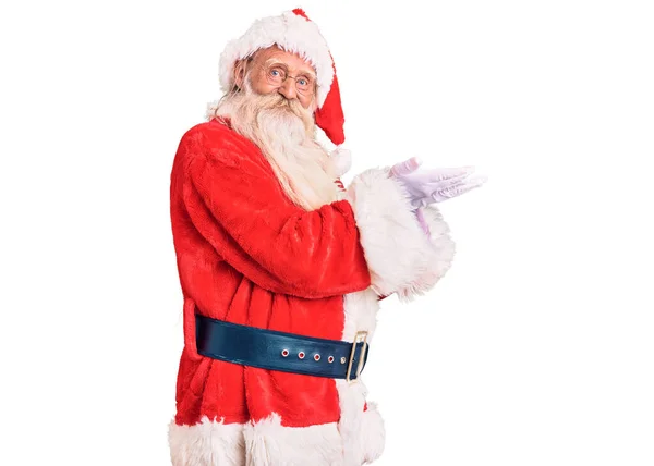 年长的老人 白发苍苍 长胡子 身穿传统的圣诞老人服装 双手张开手掌 展示复制的空间 呈现广告笑容满面 喜形于色 — 图库照片