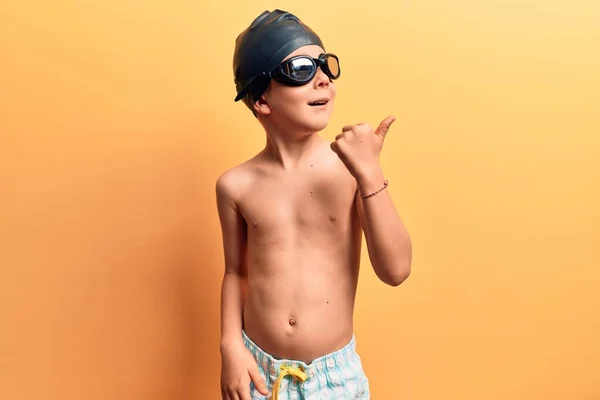 Cute Blond Kid Wearing Swimwear Swimmer Glasses Pointing Thumb Side — 图库照片