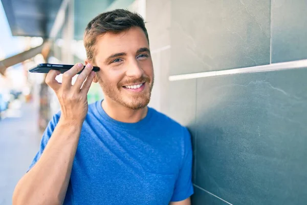 Joven Hombre Caucásico Sonriendo Feliz Escuchando Mensaje Audio Utilizando Teléfono — Foto de Stock