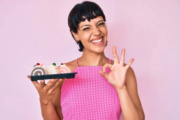 Piękna Brunetka Kobieta Trzyma Ciasto Słodycze Robi Znak Palcami Uśmiechając — Zdjęcie stockowe