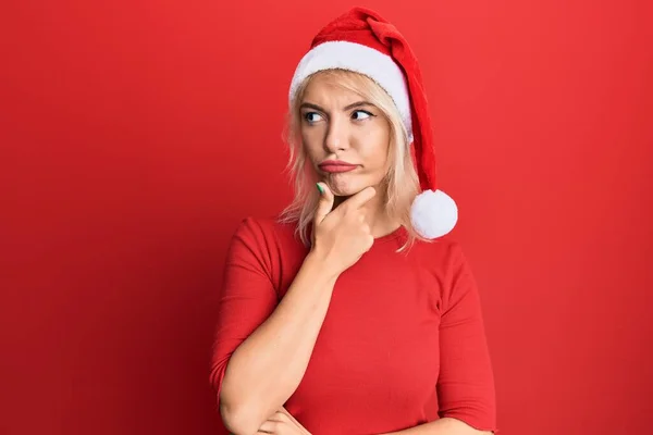 Menina Loira Jovem Usando Chapéu Natal Rosto Sério Pensando Sobre — Fotografia de Stock