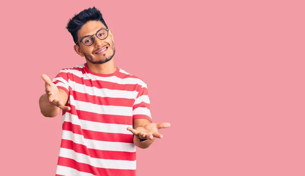 Guapo Joven Latinoamericano Usando Ropa Casual Gafas Sonriente Alegre Ofreciendo —  Fotos de Stock