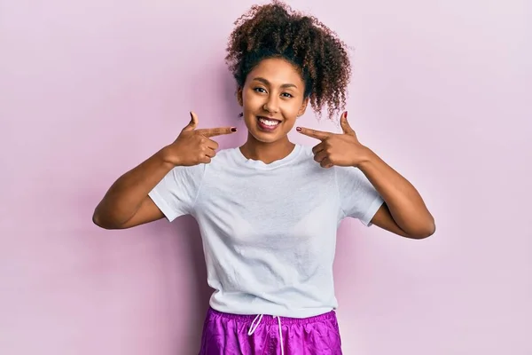 美丽的非洲裔美国女人 黑头发 身穿运动服 笑容满面 用手指 牙齿和嘴指尖 牙齿健康概念 — 图库照片