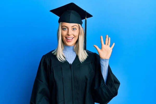 Krásná Blondýnka Sobě Maturitní Čepici Slavnostní Župan Ukazuje Ukazuje Prsty — Stock fotografie