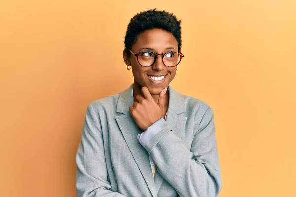 若いアフリカ系アメリカ人の少女は ビジネスジャケットや眼鏡を手に顎の質問 集中的な表現について考えて身に着けている 思慮深い顔で笑顔 疑わしい概念 — ストック写真