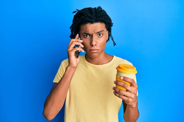若いアフリカ系アメリカ人の男性はスマートフォンを使い コーヒーを飲みながら懐疑的で緊張しており 問題のために動揺している 否定的な人 — ストック写真