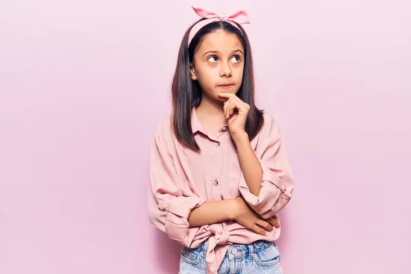 美しい子供の女の子の質問については 集中的な表現を考えて顎に手でカジュアルな服を着て 笑顔で思いやりのある顔 疑わしい概念 — ストック写真