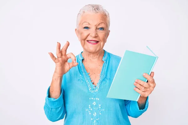 Starsza Piękna Kobieta Niebieskimi Oczami Siwymi Włosami Czytając Książkę Robi — Zdjęcie stockowe