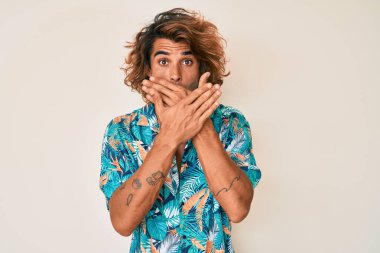 Yaz tişörtü giyen genç İspanyol adam yanlışlıkla ağzı ellerle kapatırken şok oldu. gizli kavram. 