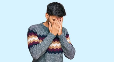 Genç, yakışıklı bir adam, sıradan bir kazak giyiyor. Ağlarken suratını ellerle kapatıyor. depresyon kavramı. 