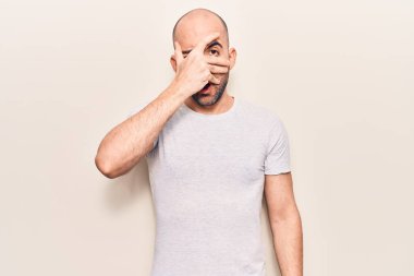 Genç, yakışıklı, kel bir adam. Günlük tişört giyiyor. Şoka girip yüzünü ve gözlerini eliyle kapatıyor. 