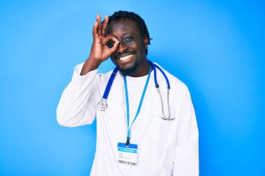 Doktor steteskop ve kimlik kartı takan genç Afrikalı Amerikalı adam gülümsüyor. 