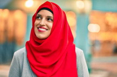 Şehre gülümseyen tesettürlü genç Arap kadın.
