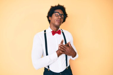 Afro saçlı, hippi görünümlü, göğsünde elleri kapalı, yüzünde minnet dolu bir jest olan yakışıklı Afro-Amerikan erkeği. sağlık kavramı. 