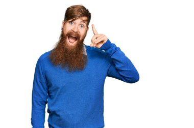 Sıradan kıyafetler giyen genç İrlandalı kızıl adam başarılı bir fikri işaret ediyor. Heyecanlı ve mutlu. Bir numara.. 