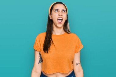 Genç İspanyol kadın gündelik kıyafetler giyiyor kızgın ve kızgın bağırıyor sinirli ve öfkeli, öfkeyle bağırıyor. öfke ve agresif konsept. 