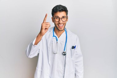 Doktor üniforması giyen genç yakışıklı bir adam ve steteskop başarılı bir fikri işaret ediyor. Heyecanlı ve mutlu. Bir numara.. 