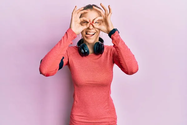 Beautiful Caucasian Woman Wearing Sportswear Arm Band Doing Gesture Binoculars — Fotografia de Stock